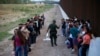 Un grupo de migrantes espera a ser procesado junto al muro fronterizo, en Eagle Pass, Texas. (AP/Dario Lopez-Mills, File)