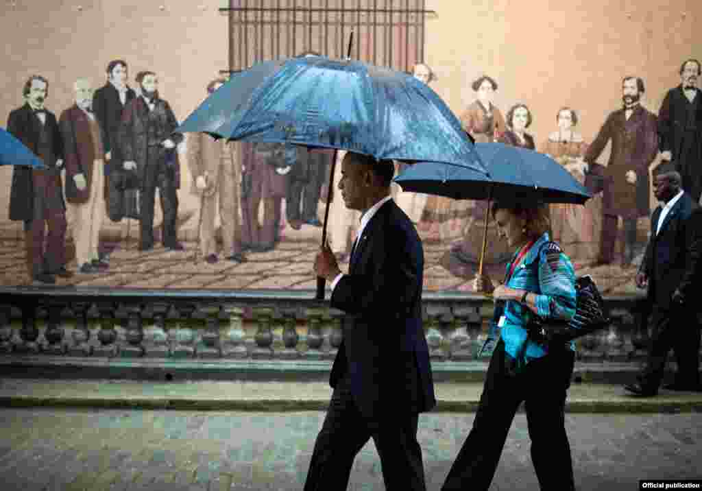 El Presidente Obama pasa frente al mural de la calle Mercaderes que presenta a figuras del arte y la historia de Cuba.
