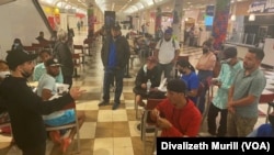 Miembros de organizaciones humanitarias reciben a migrantes trasladados de Texas a Washington DC en la zona de cafetería de Union Station, la mayoría provienen de Venezuela y Nicaragua y han sido aceptados para presentar peticiones de asilo. (Foto Divalizeth Murillo / VOA)