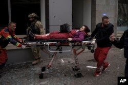 Una mujer es trasladada a una ambulancia tras resultar herida en un bombardeo ruso en Járkiv, Ucrania, el domingo 17 de abril. (AP Foto/Felipe Dana)