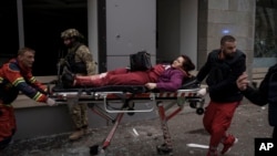 Una mujer es trasladada a una ambulancia tras resultar herida en un bombardeo ruso en Járkiv, Ucrania, el domingo 17 de abril. (AP Foto/Felipe Dana)