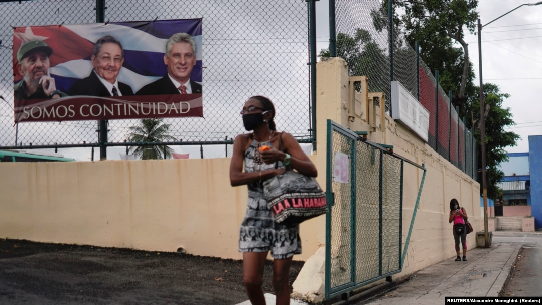 Mujer pasa frente a un cartel con el slogan del gobierno cubano "Somos continuidad". (REUTERS/Alexandre Meneghini)