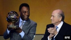 El exjugador brasileño Pelé (i) recibe el Balón de Oro de Honor de manos del presidente de la FIFA Joseph Blatter, durante la gala del Balón de Oro 2013 celebrada en Zúrich, Suiza, el 13 de enero del 2014.