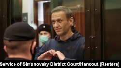  El opositor ruso Alexei Navalny hace un gesto a sus familiares durante una audiencia en una corte de Moscú. Press Service of Simonovsky District Court/Handout via REUTERS. [Foto de archivo]