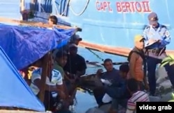Policías hondureños conversan con algunos de los 16 balseros cubanos que llegaron a La Ceiba desde Manzanillo, Cuba.