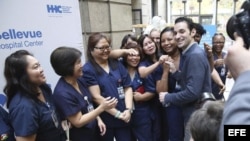 El médico estadounidense Craig Spencer, quien se había contagiado de ébola en Guinea, posa junto a empleadas del hospital de Bellevue en Nueva York.