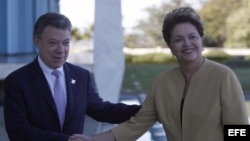 La presidenta brasileña, Dilma Rousseff (d), recibía a su homólogo de Colombia, Juan Manuel Santos (i), el jueves 19 de junio de 2014, en el Palacio de la Alvorada, residencia oficial de la mandataria brasileña, en Brasilia (Brasil).