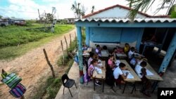 Un grupo de niños asiste a una clase en una escuela improvisada, en La Coloma, Pinar del Río, Cuba, después del paso de Ian. (YAMIL LAGE / AFP)