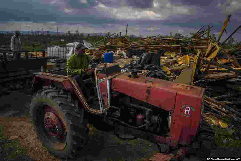 El productor de tabaco Hirochi Robaina conduce su tractor frente a graneros de tabaco destruidos en su finca una semana después del huracán Ian en San Luis, en la provincia de Pinar del Río.&nbsp;