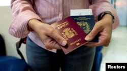 Mariana Elías muestra sus pasaportes español y venezolano en el aeropuerto Simón Bolívar, Venezuela, antes de emigrar a España. (REUTERS/Ana Maria Arevalo Gosen)