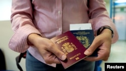 Foto de archivo. Una mujer muestra sus pasaportes. (REUTERS/Ana Maria Arevalo Gosen)