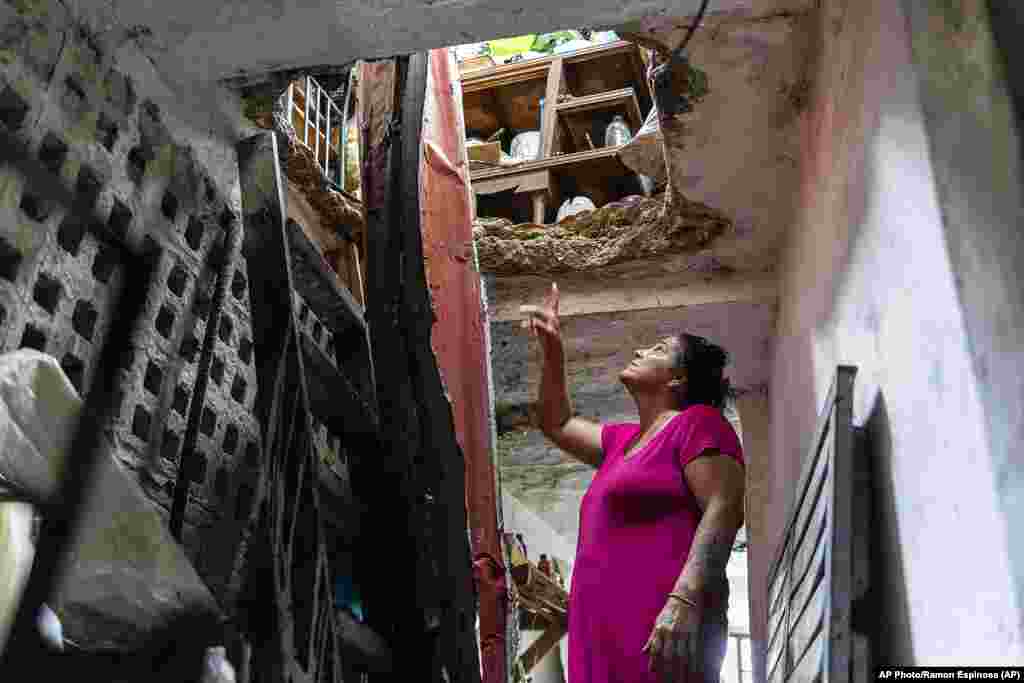 Una mujer señala los daños en su techo, sobre el segundo piso, causados ​​por el huracán Ian en Pinar del Río, Cuba, el martes 27 de septiembre de 2022. (AP Foto/Ramón Espinosa)