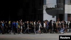 Agentes de civil con palos avanzan hacia los manifestantes de una protesta pacífica en La Habana, durante un apagón, el 30 de septiembre de 2022. 