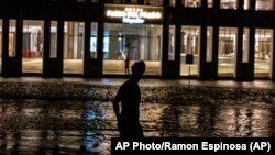 Un hombre camina por una calle inundada ante un hotel que funciona con generador, durante un apagón en La Habana, Cuba, el miércoles 28 de septiembre de 2022. (AP Foto/Ramón Espinosa)