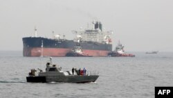 Una lancha militar iraní patrulla las aguas mientras un petrolero se prepara para atracar en las instalaciones petroleras en la isla de Khark, en Irán. 