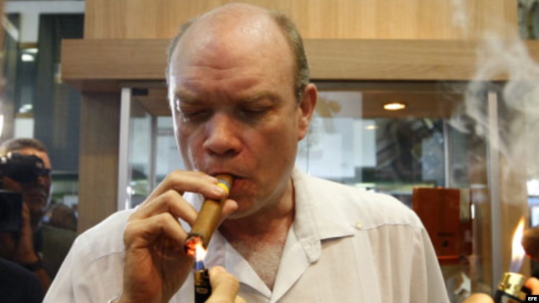El ministro cubano de Inversión Extranjera, Rodrigo Malmierca (c), enciende un puro durante la inauguración de la feria comercial del XIV Festival del Habano, en La Habana. 