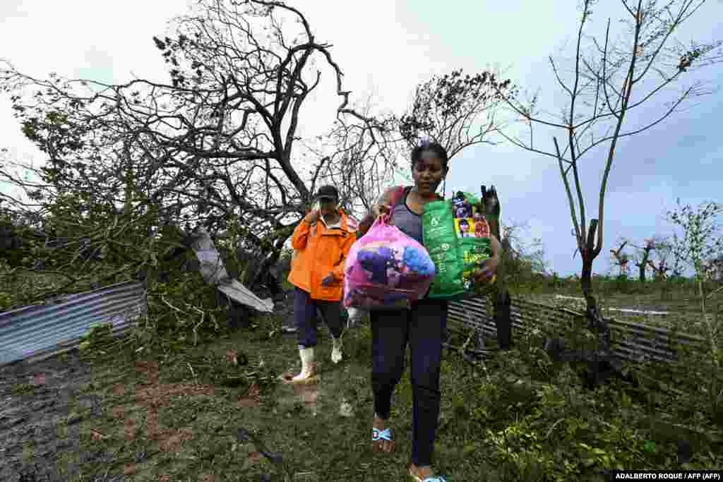Caridad Álvarez, trabajadora de una empresa tabacalera, y su esposo, Alberto Naranjo, cargan sus pertenencias después de que su casa fuera destruida por el huracán Ian, en San Juan y Martínez, provincia de Pinar del Río, Cuba, el 27 de septiembre de 2022.