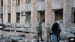 Investigadores revisan un lugar tras un ataque cerca de un edificio administrativo en Donetsk, la capital de la autoproclamada República Popular de Donetsk, en el este de Ucrania. (AP/Alexei Alexandrov)
