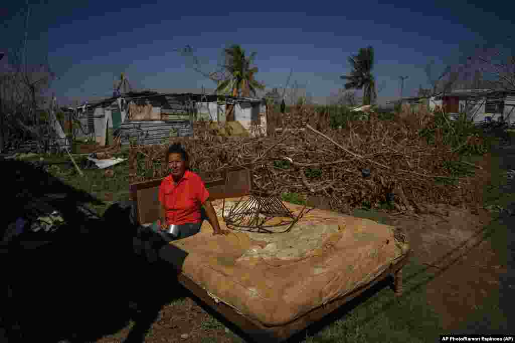 Mari Carmen Zambrano posa en su cama rota y mojada mientras la seca afuera de su casa que perdió el techo por el huracán Ian en La Coloma.