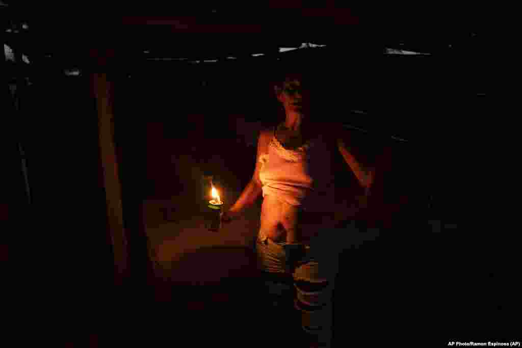 Un residente usa una lata de bencina para alumbrarse mientras sigue sin electricidad una semana después del huracán Ian en La Coloma.