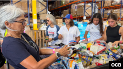 Voluntarios de todas las edades clasifican ayuda humanitaria para Venezuela en galpón de Miami. (OCB)