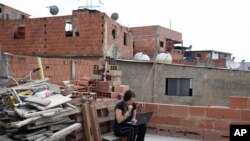 Una venezolana intenta conectarse a Internet en la azotea de su edificio en Caracas (AP/Ariana Cubillos).