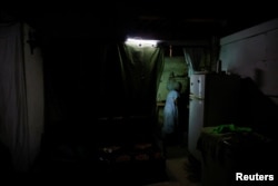La cocinera Yolanda Liquijons, de 88 años, prepara leche para el desayuno de su hija en la cocina improvisada de su refugio, La Habana, Cuba, 7 de julio de 2026. REUTERS/Norlys Perez