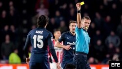 El árbitro Daniele Orsato (d) amonesta con tarjeta amarilla a Stefan Savic (i), del Atlético de Madrid, hoy, miércoles 24 de febrero de 2016.