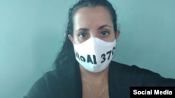 La periodista y activista Camila Acosta con una mascarilla que reza: "No al 370". 