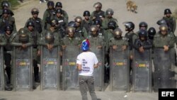 Un manifestante protesta frente a integrantes de la Guardia Nacional Bolivariana