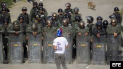 Un manifestante protesta frente a integrantes de la Guardia Nacional Bolivariana