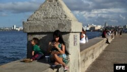 Una joven se conecta a internet en el muro del Malecón, en La Habana.