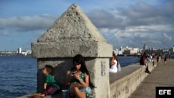 Una joven se conecta a internet en el muro del Malecón, en La Habana.