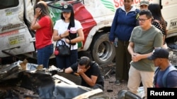 Familiares de las víctimas reaccionan junto a los vehículos destruidos por el ataque con explosivos en la Panamericana.