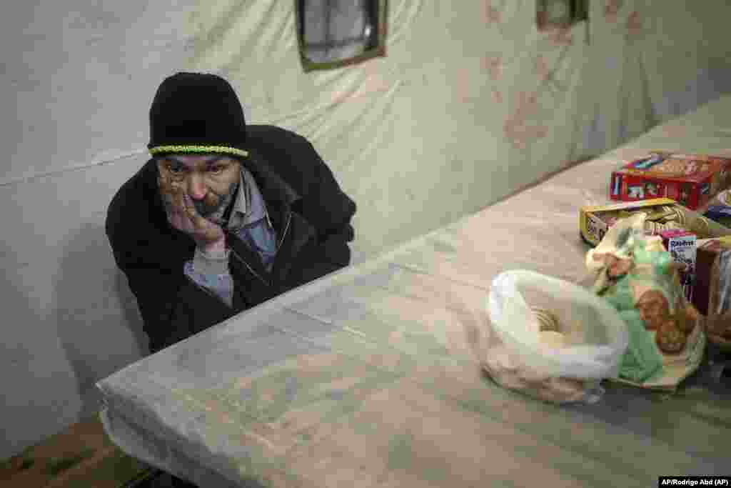 Borya, de 58 años, evacuado de la ciudad de Baryshivka por el gobierno ucraniano debido a los intensos combates, espera dentro de una tienda de campaña tras llegar a Brovary, en las afueras de Kiev, Ucrania, el martes 29 de marzo de 2022. (AP Foto/Rodrigo Abd)