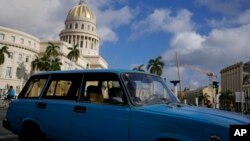 Un conductor maneja una camioneta Lada antigua de fabricación rusa frente al Capitolio en La Habana, Cuba, el viernes 1 de abril de 2022. (AP Foto/Ramón Espinosa)