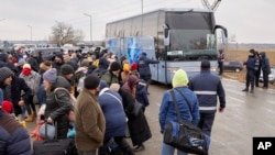 Refugiados que huyen de la guerra en Ucrania esperan para abordar un autobús en Palanca, Moldavia, el martes 1 de marzo de 2022. (AP Foto/Aurel Obreja)
