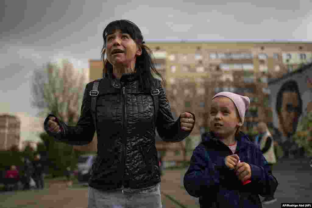 Julia, de 34 años, llora junto a su hija Veronika, de 6 años, mientras habla con un grupo de periodistas en Brovary, en las afueras de Kiev, Ucrania, el martes 29 de marzo de 2022. (AP Foto/Rodrigo Abd)