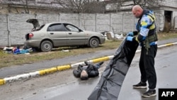 Recogida de cadáveres en las calles de Bucha tras ser liberada de las tropas rusas. (AFP/Sergei Supinsky).