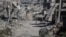 Palestinos se abren paso entre edificios destruidos en Jan Yunis, en el sur de la Franja de Gaza, el 31 de julio de 2026.