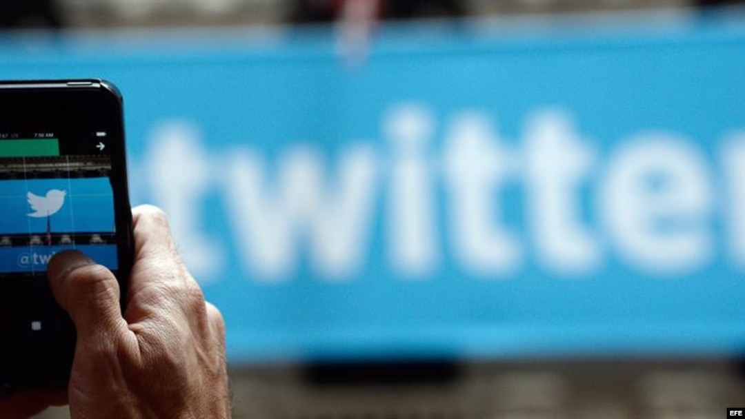Un transeúnte toma fotografías al logo de la red social Twitter.