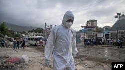 Un forense camina entre los escombros de edificios dañados por los terremotos del 24 de junio, en Tanaguarena, estado de La Guaira (Venezuela).