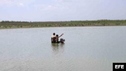 En esta foto varias personas recojen agua en una de las presa en el oriente del país. 