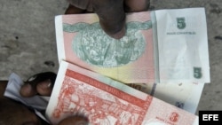 Una persona muestra la nueva serie de billetes de pesos convertibles cubanos.