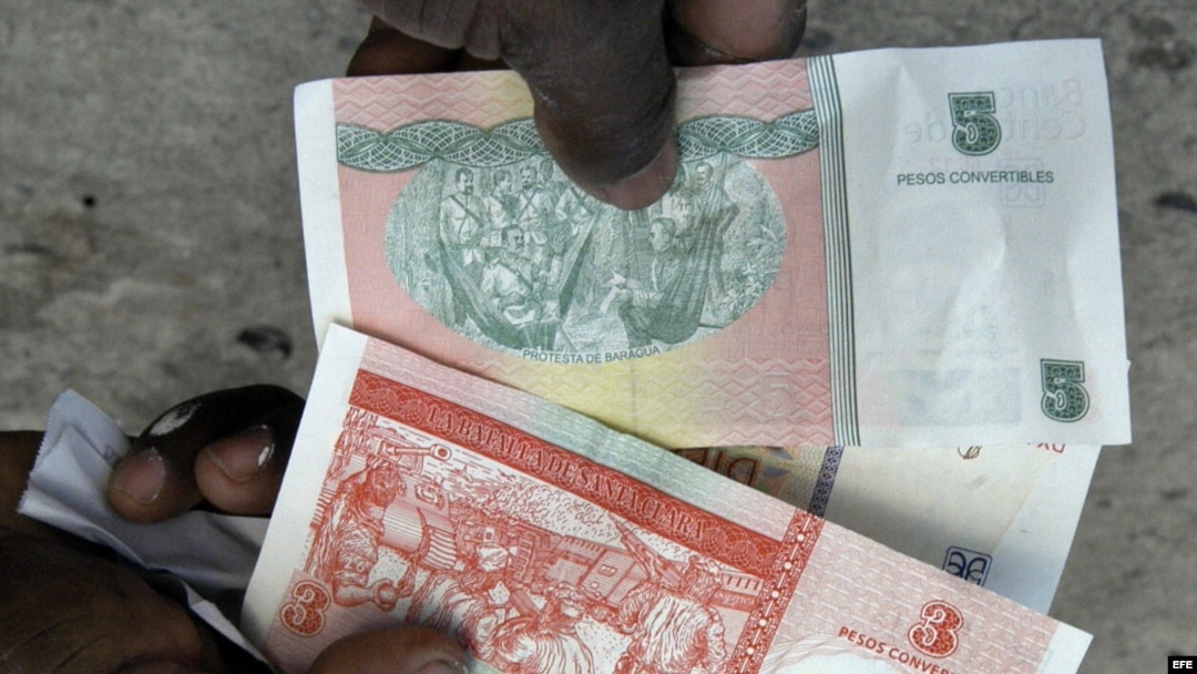 Una persona muestra la nueva serie de billetes de pesos convertibles cubanos.