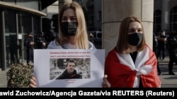 Una mujer sostiene un cartel durante una protesta en contra del arresto del bloguero bielorruso, Roman Protasevich