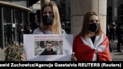 Una mujer sostiene un cartel durante una protesta en contra del arresto del bloguero bielorruso, Roman Protasevich