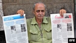 Un vendedor de periódicos en La Habana muestra el diario oficial Granma y Juventud Rebelde, con la misma portada. 