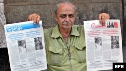 Un vendedor de periódicos en La Habana muestra el diario oficial Granma y Juventud Rebelde, con la misma portada. 