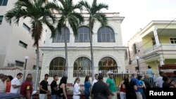 Los cubanos hacen cola frente a una de las oficinas donde entregan pasaportes en La Habana, Cuba. Foto de archivo.